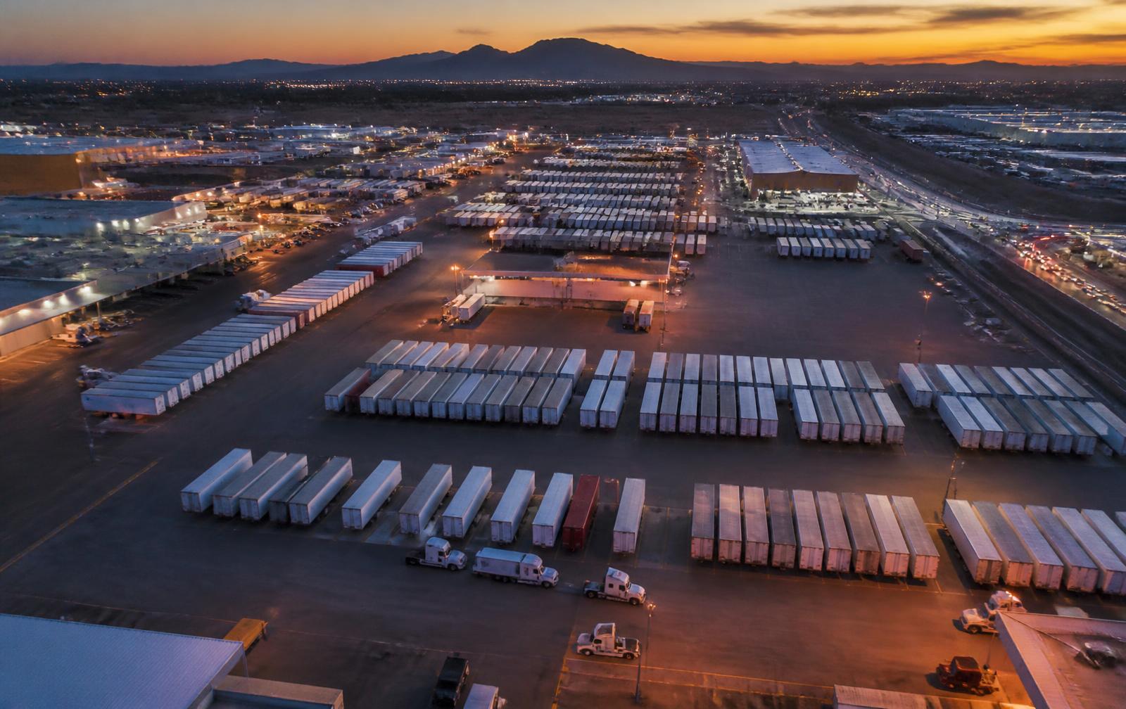 Aerial view of a Laredo-area truck yard with rows of trailers at dusk
